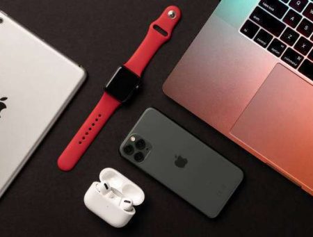 Flat Lay of different apple products on a dark grey background.
